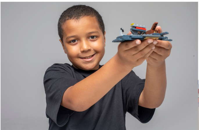 Child concentrating on a LEGO build during a Baseplate Labs party